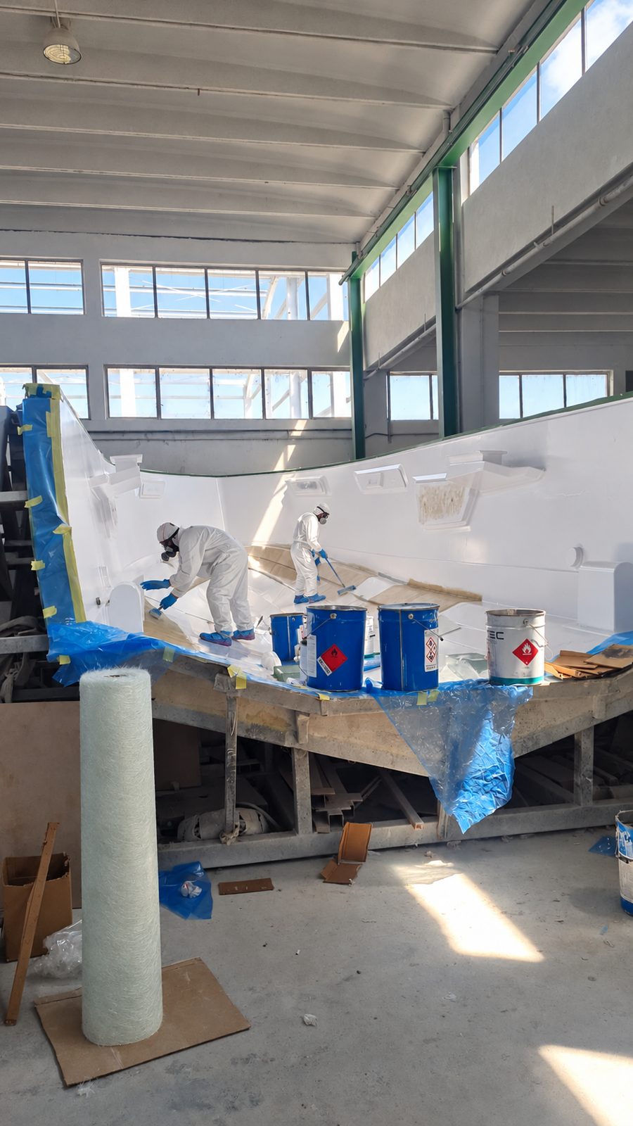 Echipă echipată complet lucrând în interiorul unei matrițe de carenă